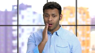 Dişi ağrıyan koyu tenli genç bir adam..