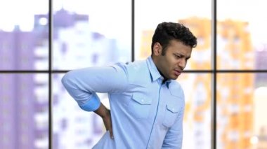 Koyu tenli genç adam korkunç bir sırt ağrısı çekiyor..