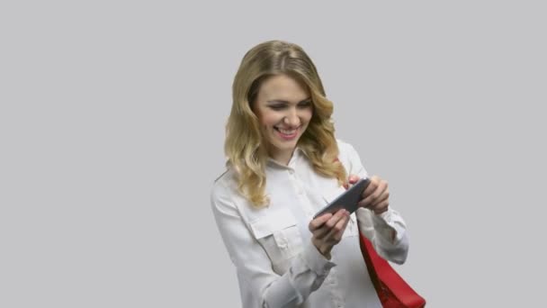 Young attractive woman in formal shirt playing game on her smartphone. — Stock Video