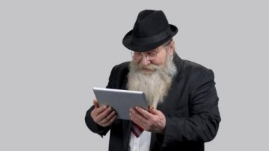 Yaşlı kıdemli işadamı tabletini izlerken kahkahalar atıyor..