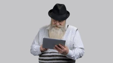 Yaşlı emekli büyükbaba internette tablet bilgisayar kullanarak sörf yapıyor..