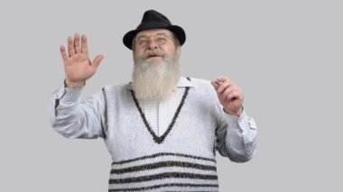 Yaşlı bir adam sanal ortamda görünmeyen bir ekrana dokunuyor..