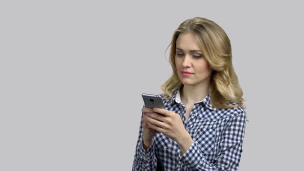 Молодая блондинка печатает сообщение на смартфоне . — стоковое видео