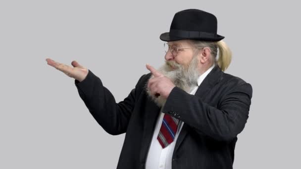 Old aged man in suit pointing at his empty palm, copyspace. — Stock Video