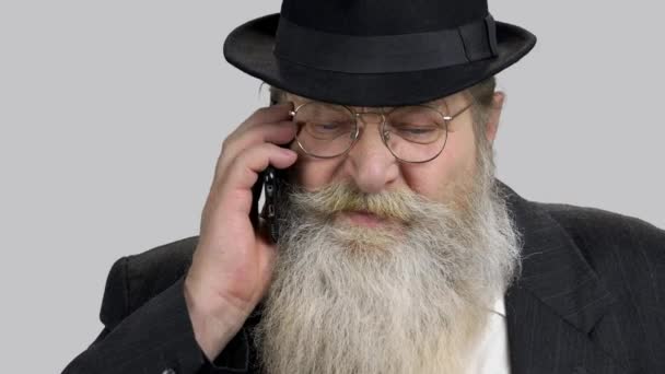 Close-up portret ernstige senior zakenman praten op telefoon. — Stockvideo