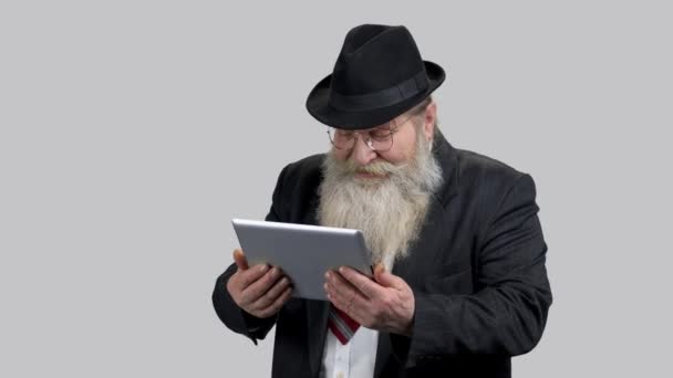 Oude senior zakenman lachen hardop kijken op zijn tablet pc. — Stockvideo