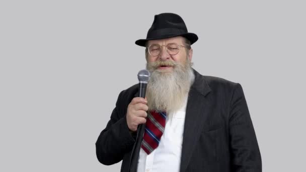 Smiling old senior speaker with long beard giving speech with microphone. — Stock Video