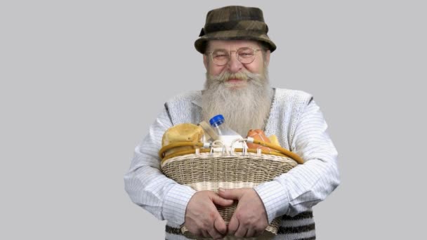 Portrait of happy grandpa with straw basket of food. — Stock Video