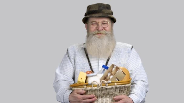 Portret szczęśliwego emerytowanego dziadka ze słomkowym koszem żywności spożywczej. — Wideo stockowe