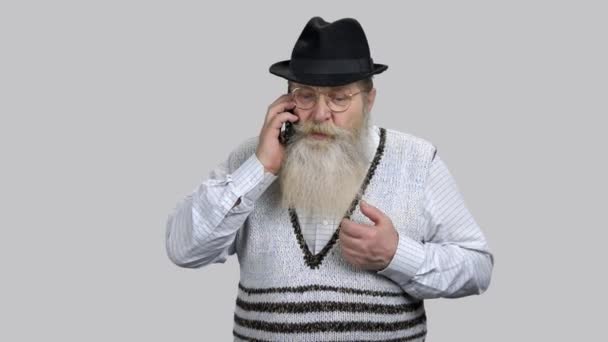 Θυμωμένος γέρος συνταξιούχος μιλάει στο τηλέφωνο. — Αρχείο Βίντεο