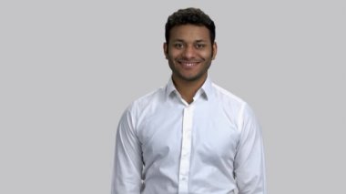 Beyaz resmi gömlek giyen mutlu, kahverengi tenli bir adamın portresi..