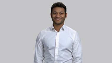 Genç mutlu kahverengi tenli adam kollarını kavuşturuyor..