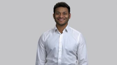 Kahverengi tenli mutlu genç adamın portresi baş parmağını gösteriyor..