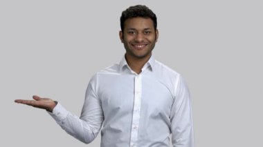 Mutlu genç Hintli adam, kopyalanmak için boş avucunu işaret ediyor..