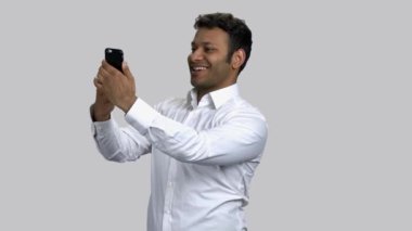 Genç Hintli adam fotoğraf makinesinde poz veriyor ve selfie çekiyor..