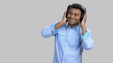 Çekici, koyu tenli, kulaklıkla müzik dinleyen bir adam..