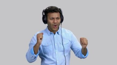 Koyu tenli mutlu bir adam kulaklıkla rock müzik dinliyor..