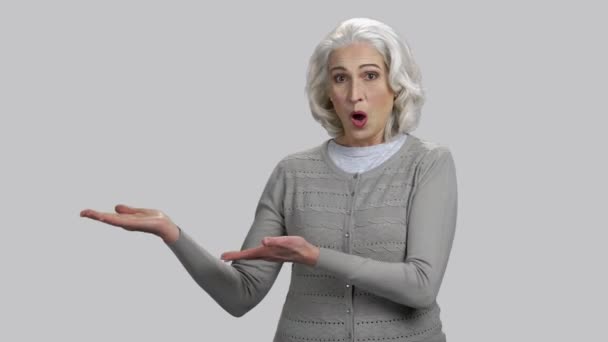 Emocional senhora idosa positiva demonstrando com suas duas palmas para cima . — Vídeo de Stock