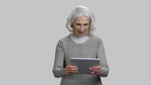 Old retired lady playing video game on her tablet pc. — Stock Video