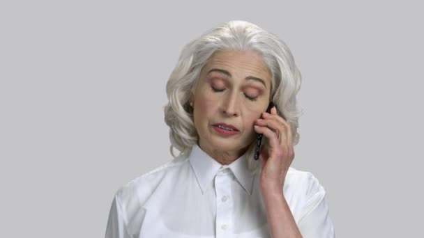 Portret van een oude dame met grijs haar aan het praten op de mobiele telefoon. — Stockvideo