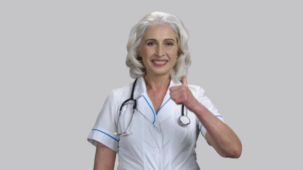 Gammal äldre kvinnlig läkare visar tummen upp. — Stockvideo