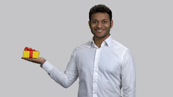 Happy hindu man holding gift box and pointing with hand. — Stock Video