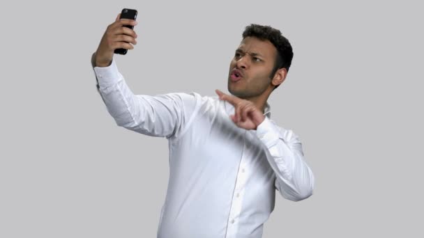 Donkere man neemt selfies op zijn frontale camera en poseert. — Stockvideo