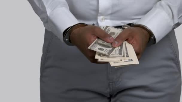 Close up dark skinned hands with money locked in handcuffs. — Stock Video