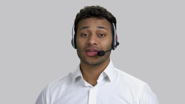 Portrait of happy dark-skinned man with headset is talking. — Stock Video