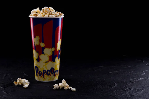 Full popcorn i klassisk popcorn box på mycket mörk bakgrund. — Stockfoto