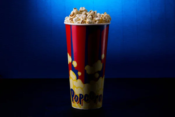 Full popcorn hink box på mörkblå bakgrund. — Stockfoto