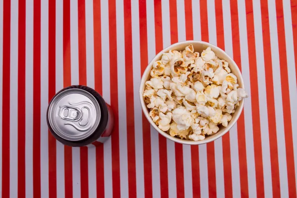 Popcorn hink box och läsk dryck på randig bakgrund. — Stockfoto