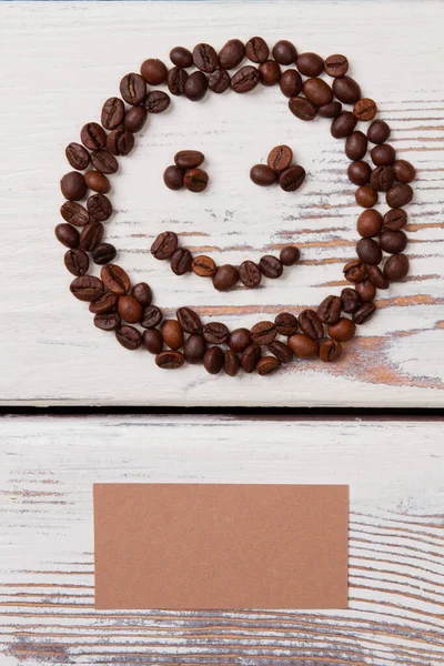 Prázdný béžový papír a kávová zrna ve tvaru usměvavé tváře. — Stock fotografie