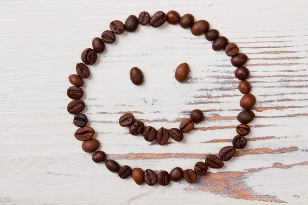 Coffee beans arranged in a happy smiley face.