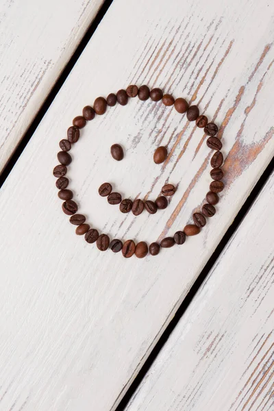 Happy smiley face made of brown coffee beans.