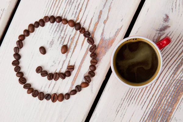 Top vista xícara de café quente e rosto sorridente . — Fotografia de Stock