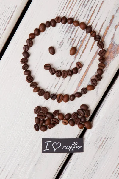 Smiley ansikte med fluga gjord av kaffebönor. — Stockfoto