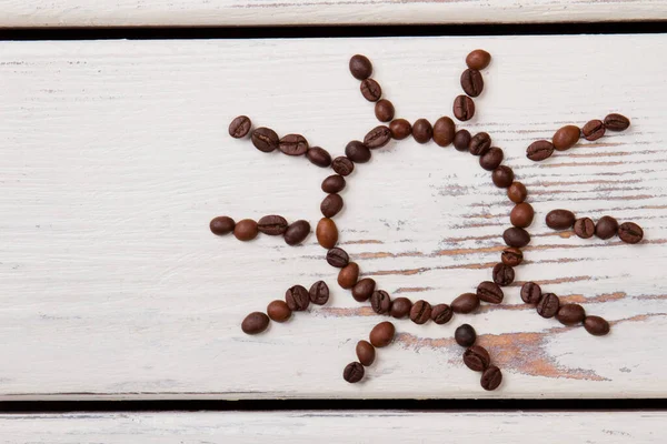 焙煎したコーヒー豆で作られた太陽の形. — ストック写真