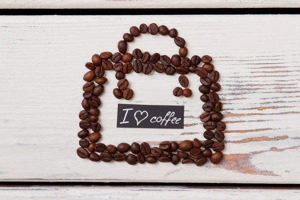 Granos de café en madera dispuestos en forma de bolso . — Foto de Stock