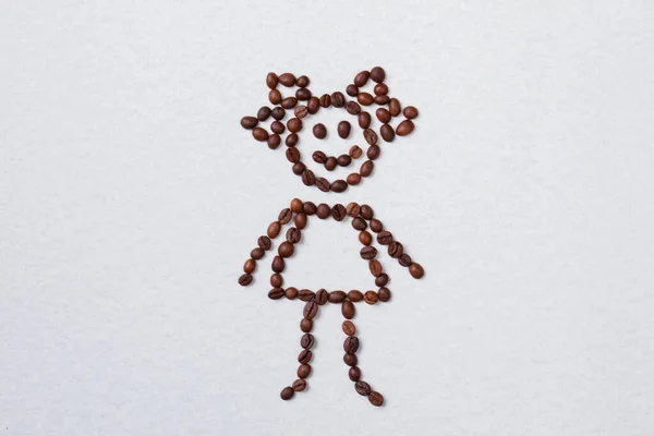 Grains de café brun disposés dans une forme de fille . — Photo