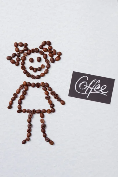 コーヒー豆で作られた幸せな象徴的な女の子. — ストック写真