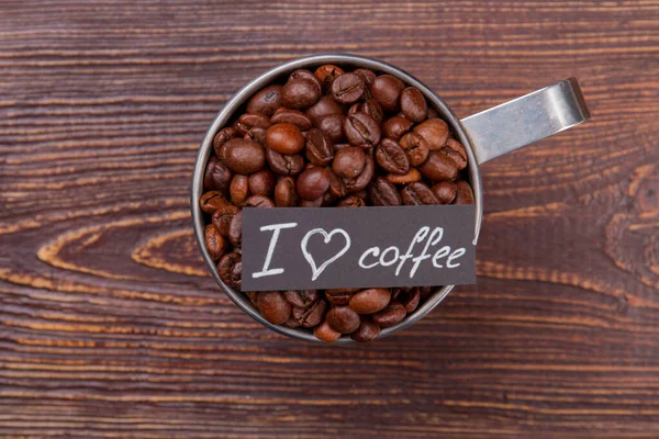 Tasse à café en acier pleine de grains de café vue de dessus . — Photo