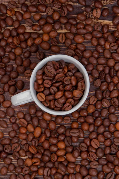 Witte beker vol koffiebonen bovenaanzicht. — Stockfoto