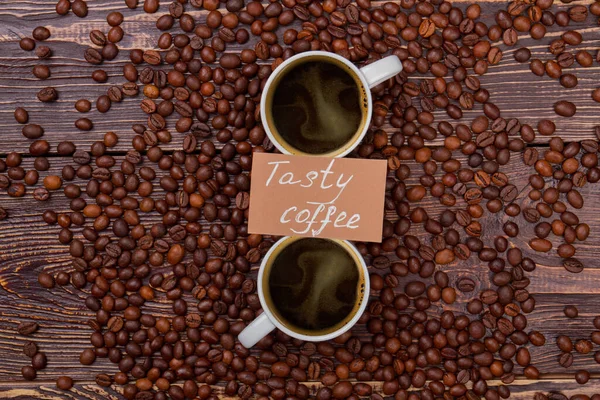 Tasty coffee cups on coffee beans. — Stock Photo, Image