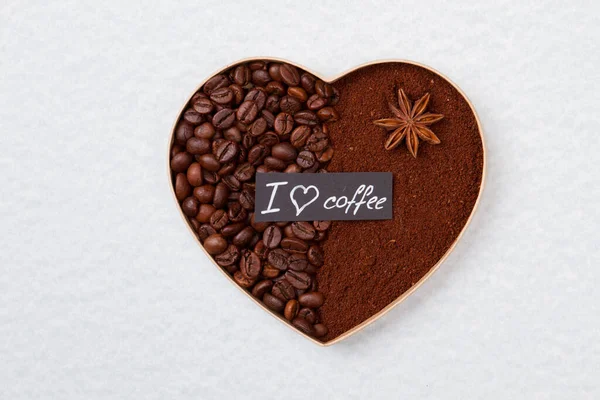 Forma srdce z kávových zrn a prášku. — Stock fotografie