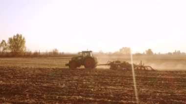 Güneşli bir günde tarlada çalışan traktör..