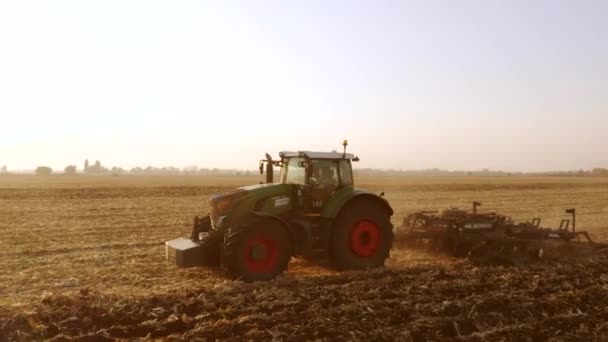 Zielony ciągnik pracujący na polu. — Wideo stockowe