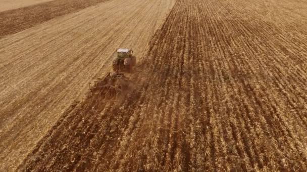収穫後の畑を耕すトラクターのトップビュー. — ストック動画
