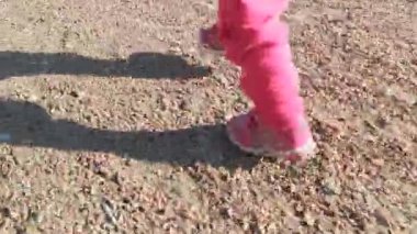 Pembe spor ayakkabılarla yürümeye başlayan çocuklar..