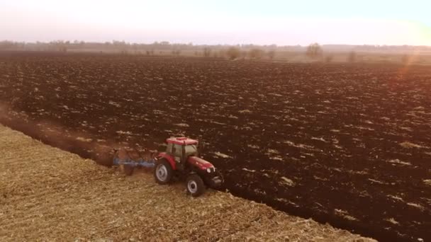 Tractor ploegen bodem van een grote boerderij veld. — Stockvideo